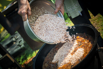 Hot pilaf in large cauldron outdoors. Tasty pilaf at street.