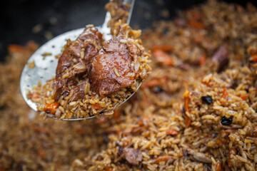 Hot pilaf in large cauldron outdoors. Tasty pilaf at street.