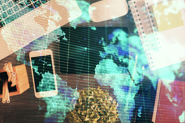 Double exposure of business theme hologram over desktop with phone. Top view. Mobile international trade connection concept.