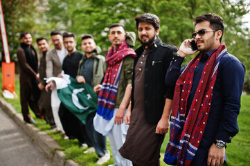 Obraz premium Group of pakistani man wearing traditional clothes salwar kameez or kurta with Pakistan flags.