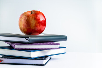 Books and apple on white background. Back to school concept. Place for text.