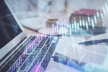 Double exposure of financial chart drawing and desktop with coffee and items on table background. Concept of forex market trading