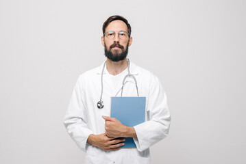 A young male doctor holds a stethoscope on an isolated white background. The concept of a European doctor.