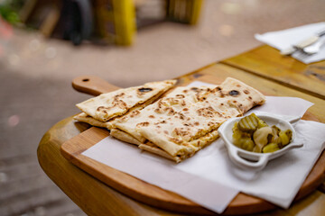 High angle view of flatbread with pickles served on table at sidewalk cafe