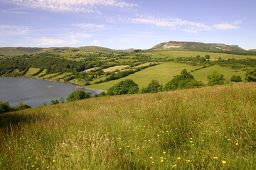 Fototapeta na wymiar Landscape at Calry, County, Sligo, Ireland featuring rolling hills, green fields, lake and mountains during summertime