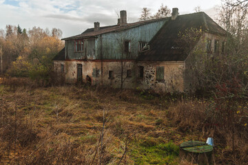 Dilapidated and abandoned former distillery from manor times in Kaleši, Latvia, and old well with metal bucket.