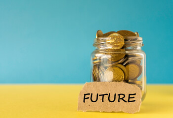 Glass jar and coins with future text on blue yellow background, saving concept