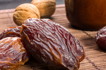 Big luxury dried date fruit on the bamboo mat, kurma ramadan kareem concept, close up.