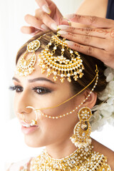 Beautiful female model wearing traditional Sikh wedding attire as she prepares for the ceremony