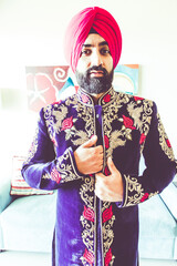 Sikh male model in traditional wedding attire preparing for ceremony