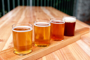 Beer tasting. Diferent beer in 100 mililiter glases over wooden table.