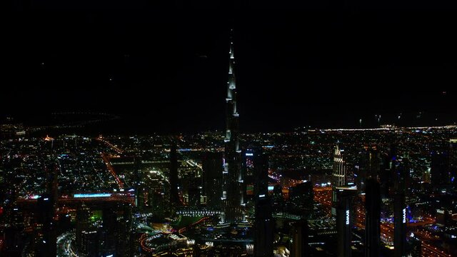 Beautiful lights lit on the Burj Khalifa and on the Dubai Fountain showcasing an aerial view of the city at night as a wonderful cityscape, 6-axis stabilized gimbal, Shotover F1, 8K, parallax.