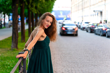 Young beautiful girl posing near a metal fence