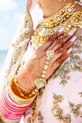 Beautiful Sikh model wearing traditional wedding ceremony clothing on clear sandy beach