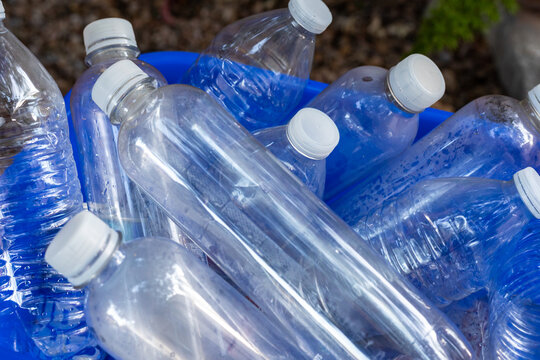 Blue recycling can full of empty plastic water bottles