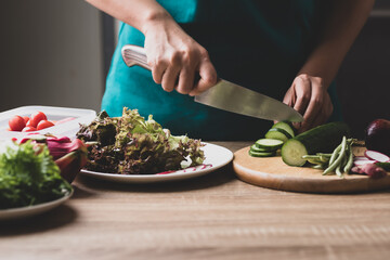 Woman preparing fresh fruits and vegetables for cooking salad, Healthy vegan food