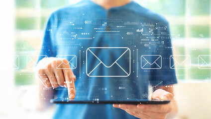 Email concept with young man using a tablet computer