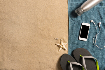 Fototapeta na wymiar Top view straw hat,headphones and smartphone with copy space. Traveler accessories on sand. Travel vacation concept. Summer background. Border composition made of towel