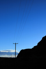 vertical photo of power lines against blue sky