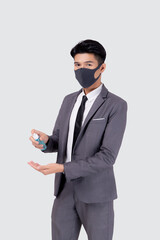 Young asian businessman in suit wearing face mask and cleaning hand with alcohol for protective covid-19 isolated on white background, medical mask and healthcare, impact for pandemic coronavirus.