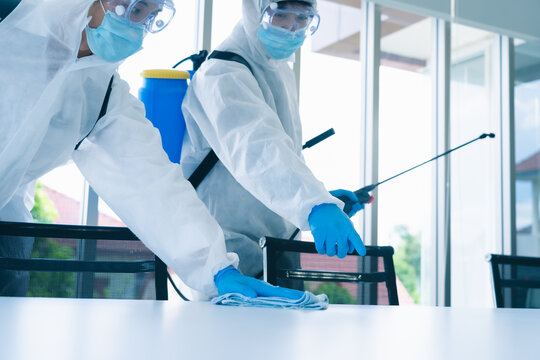 Man in virus protective suite and mask spraying alcohol cleaning covid19 infected area, Virus disinfection concept