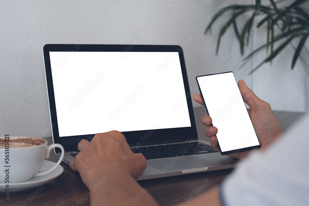 Poster mockup of man using smartphone and laptop computer while online working in coffee shop