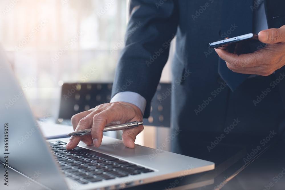 Aufkleber multitasking businessman manager using mobile phone while busy working on laptop computer in office