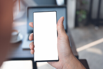 Mockup of man hand using blank screen mobile phone in office