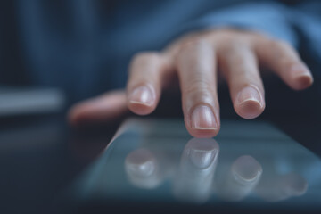 Closeup of woman finger touching on screen while using mobile phone