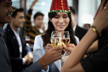 Business people or team or friend or colleagues are drinking together with glass of champagne or alcohol in party after work, happy new year celebration fun in office