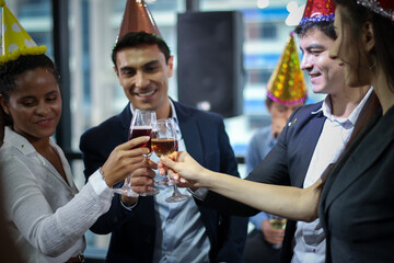 Business people or team or friend or colleagues are drinking together with glass of champagne or alcohol in party after work, happy new year celebration fun in office