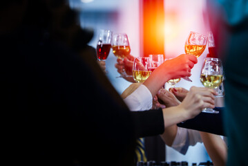 Business people or team or friend or colleagues are drinking together with glass of champagne or alcohol in party after work, happy new year celebration fun in office