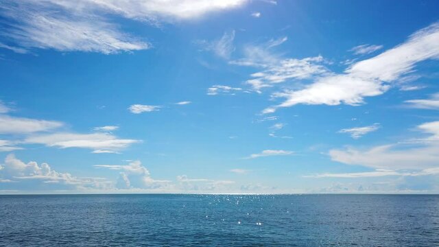 Clear blue ocean and blue sky with horizontal line, sun light reflection in calm sea, 4K