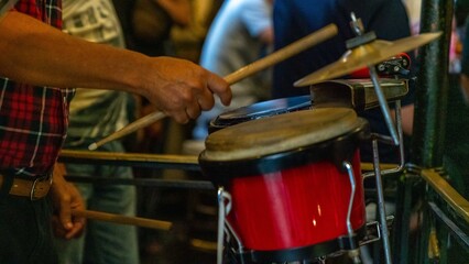 Havana, Cuba. A group of young people forming a band street performing on the streets of the vibrant capital. Beautiful woman playing at the drums.