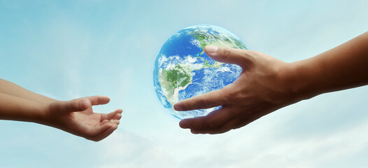 concept - hands of adult giving planet earth to child - elements of this image furnished by NASA