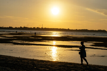 Woman walking on the beach at sunset in Gili Air Indonesia