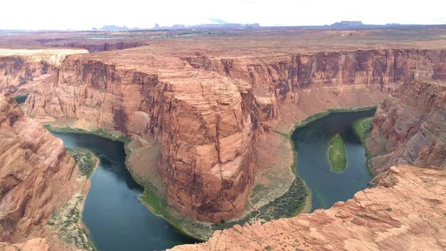World famous tourists attraction - Horseshoe bend on a cloudy day. Cinematic American Wild West wilderness nature. Aerial red canyon and Colorado river. USA travel and road trip concept footage