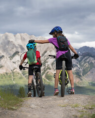 Fototapeta premium A big sister is comforting a little brother on a family mountain bike ride in Kananaskis Alberta Canada.