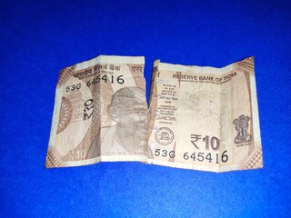 Torn Ten rupees Indian note on blue background Isolated