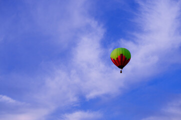 one balloon of red green in the pink blue sky flies away into the distance
