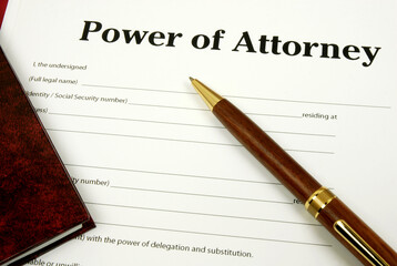 Power Of Attorney form with pen and lawbook.