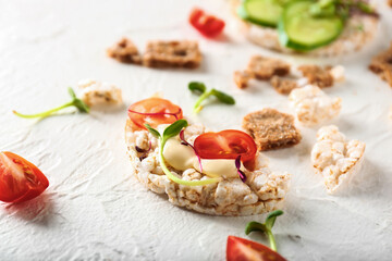 Tasty crispbread with tomato, cheese and sprouts on white background