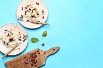 Plates with tasty rice, beans and vegetables on color background