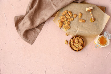 Board with crispy rice bars and honey on color background
