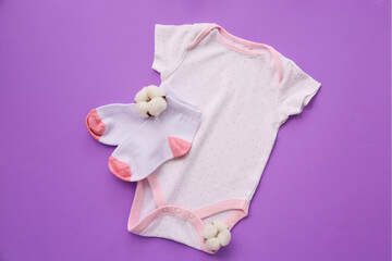 Cotton baby clothes on color background