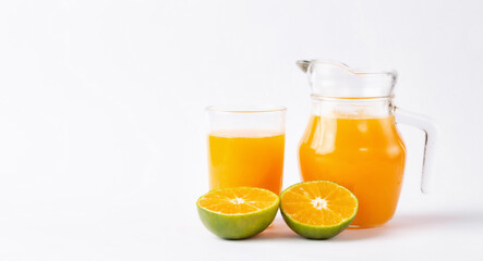 Jug, glass of orange juice and orange fruits with green leaves  on white background