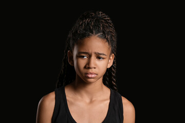 Sad African-American girl on dark background. Stop racism