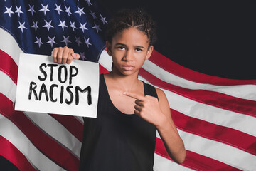Sad African-American girl with poster against USA flag. Stop racism