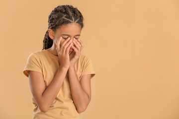 Sad African-American girl on color background. Stop racism