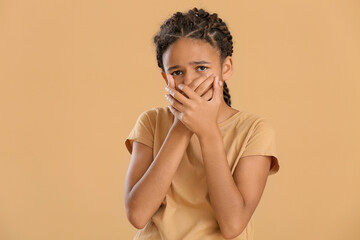 Sad African-American girl on color background. Stop racism